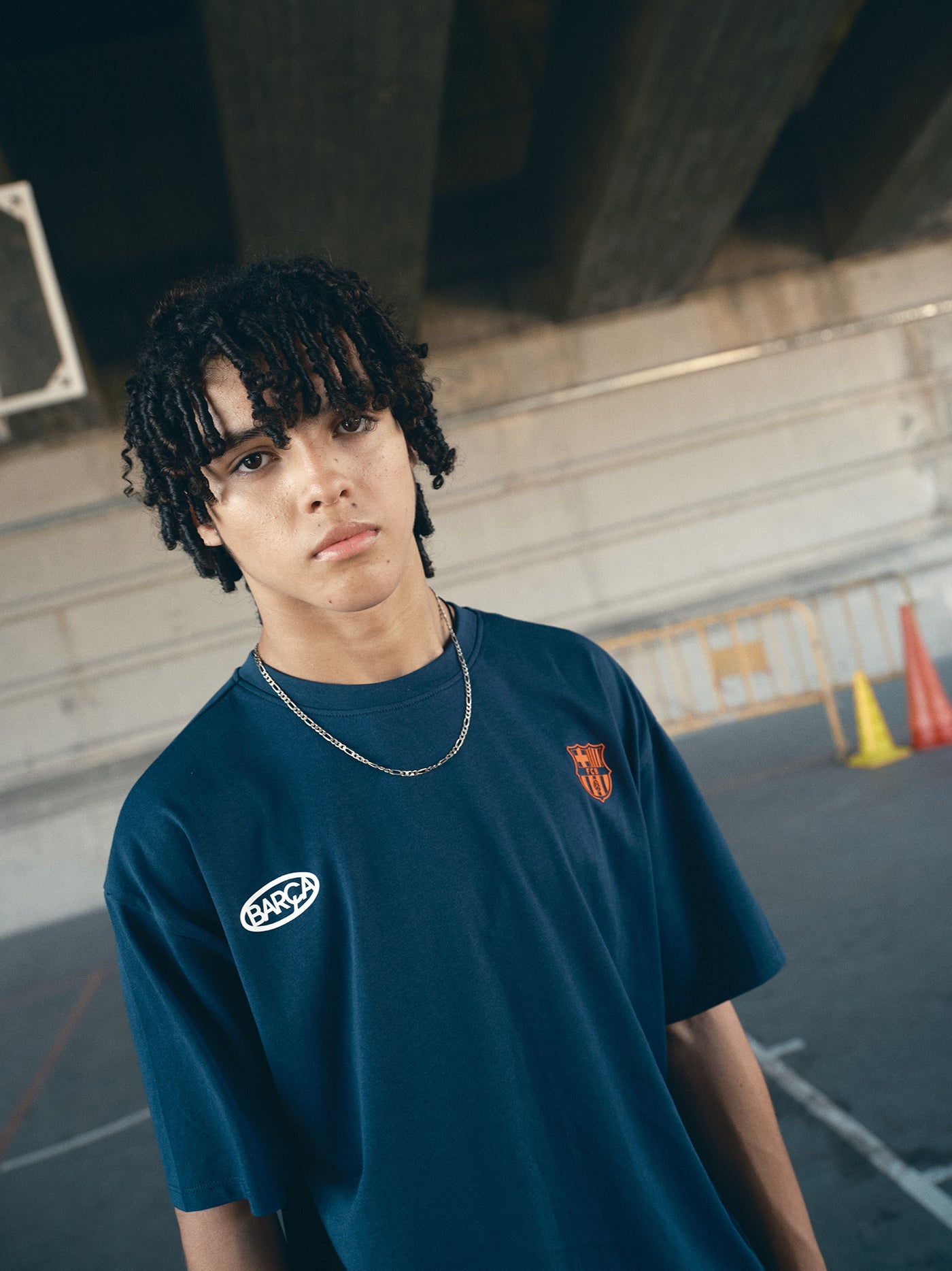 navy blue FC Barcelona t-shirt with the text 'CULERS OF THE WORLD' in orange and a white line illustration of a footballer kicking a ball.