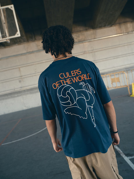 navy blue FC Barcelona t-shirt with the text 'CULERS OF THE WORLD' in orange and a white line illustration of a footballer kicking a ball.