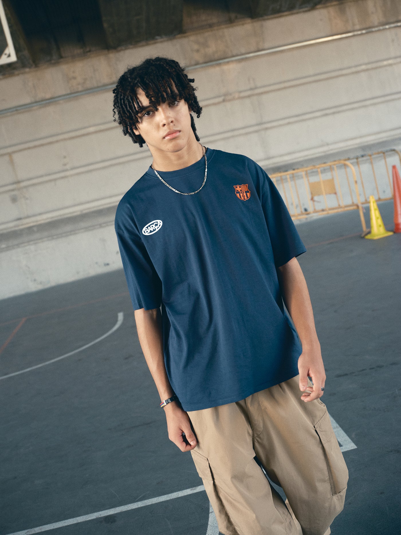 navy blue FC Barcelona t-shirt with the text 'CULERS OF THE WORLD' in orange and a white line illustration of a footballer kicking a ball.