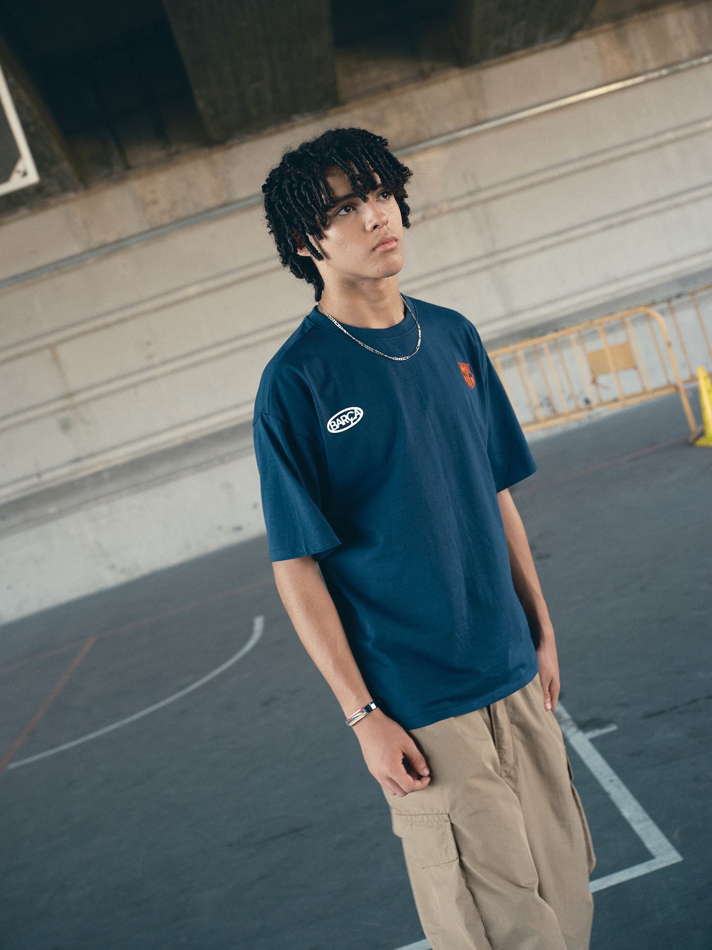 navy blue FC Barcelona t-shirt with the text 'CULERS OF THE WORLD' in orange and a white line illustration of a footballer kicking a ball.