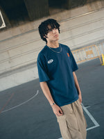 navy blue FC Barcelona t-shirt with the text 'CULERS OF THE WORLD' in orange and a white line illustration of a footballer kicking a ball.