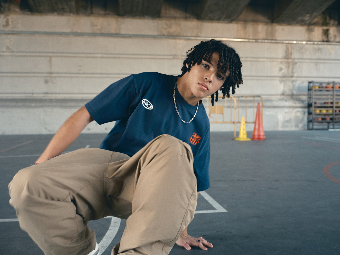 navy blue FC Barcelona t-shirt with the text 'CULERS OF THE WORLD' in orange and a white line illustration of a footballer kicking a ball.