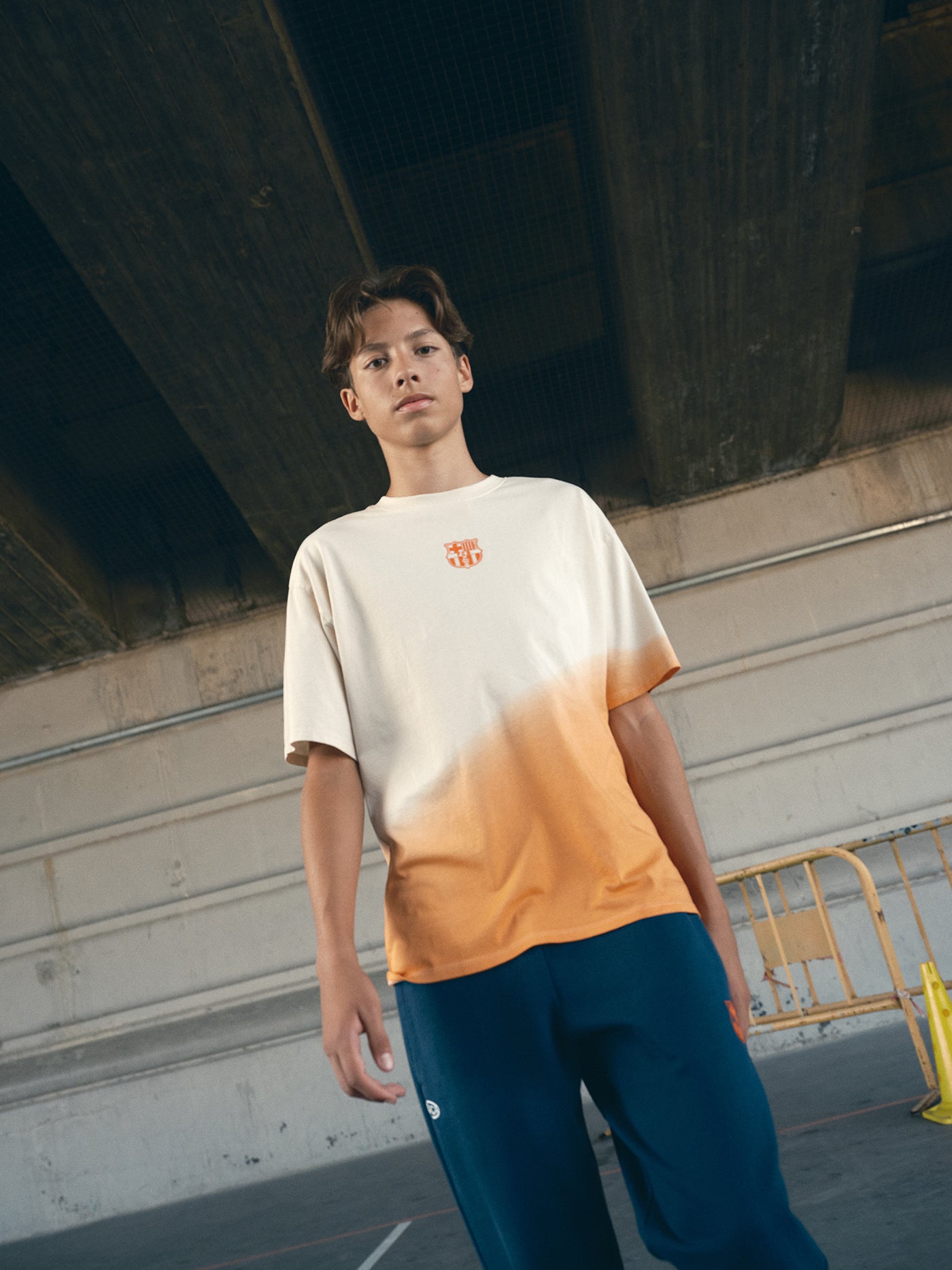 beige and orange gradient FC Barcelona t-shirt with 'EST. 1899' printed in bold orange text.