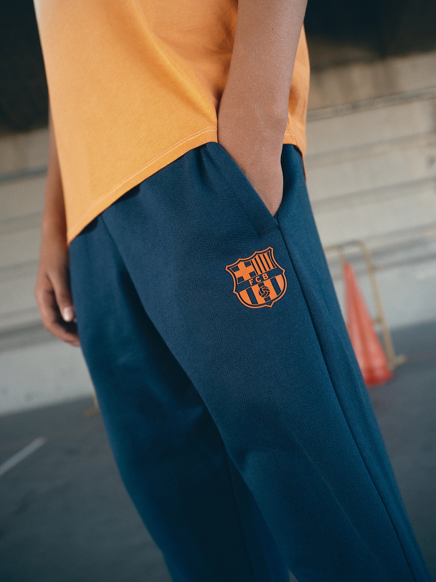 navy blue FC Barcelona sweatpants featuring the club crest in orange on the thigh