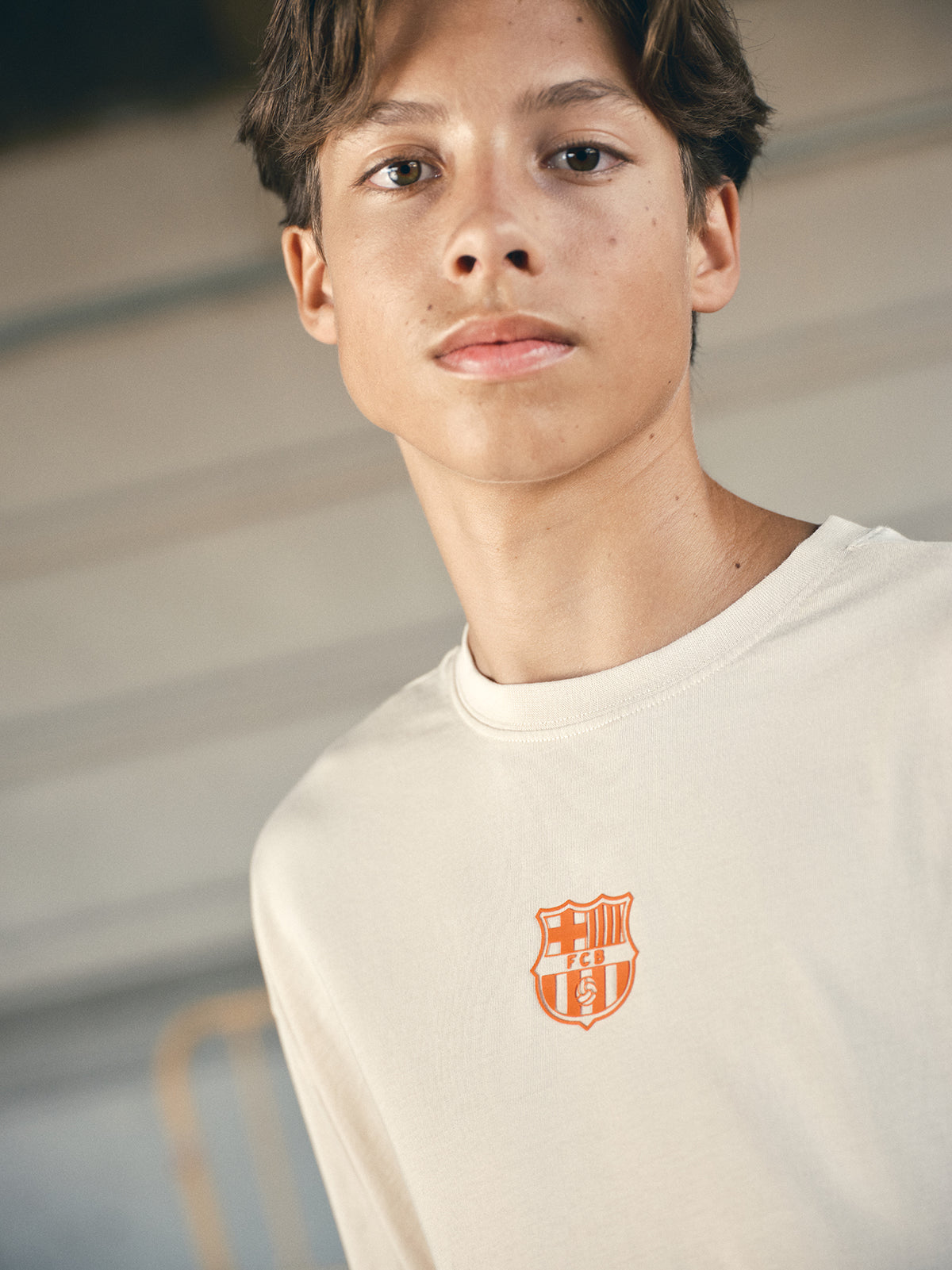 beige and orange gradient FC Barcelona t-shirt with 'EST. 1899' printed in bold orange text.