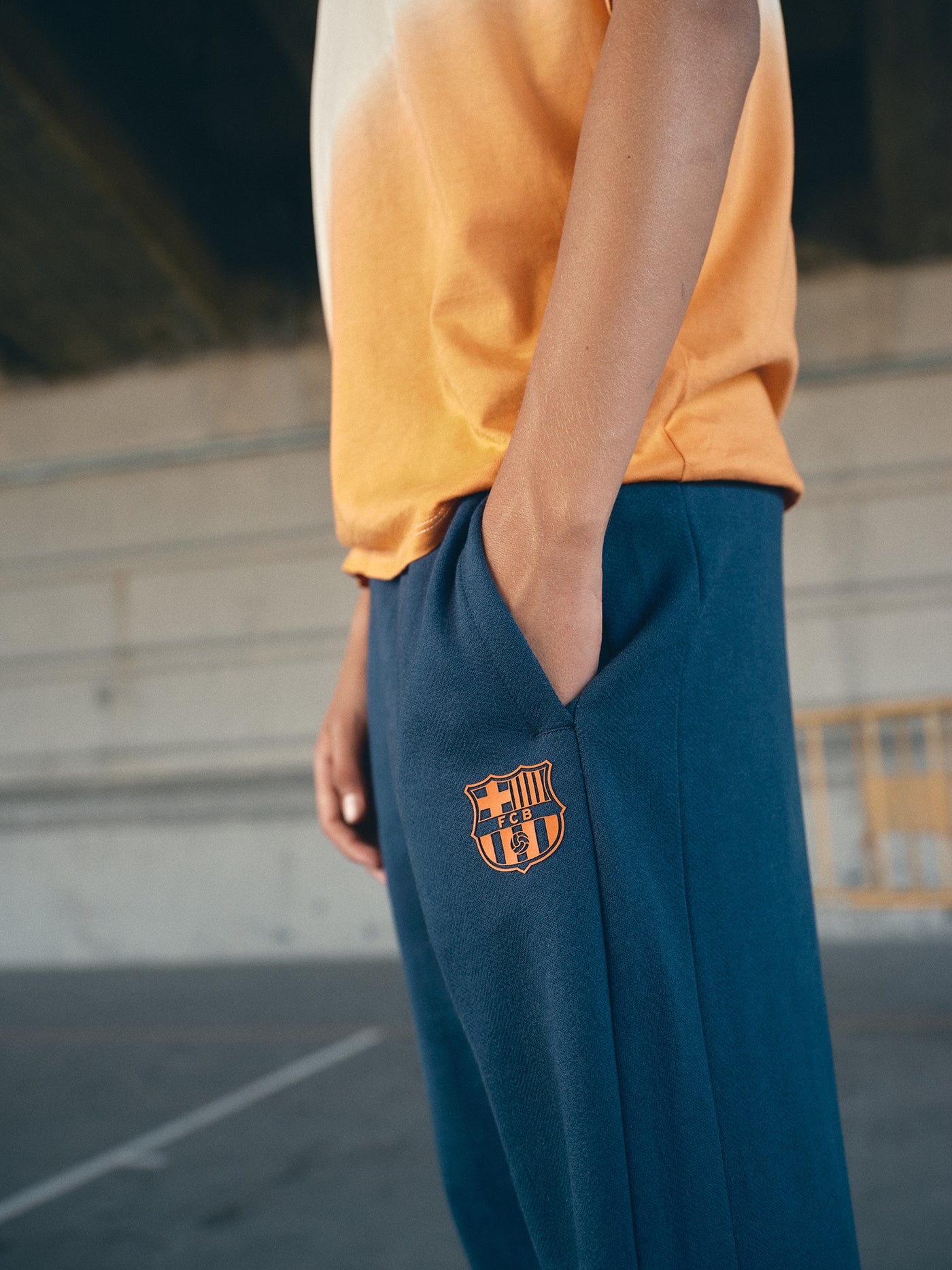 navy blue FC Barcelona sweatpants featuring the club crest in orange on the thigh