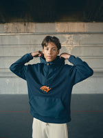 navy blue FC Barcelona hoodie featuring a front zipper and an orange graffiti-style 'FCB' logo printed on the chest