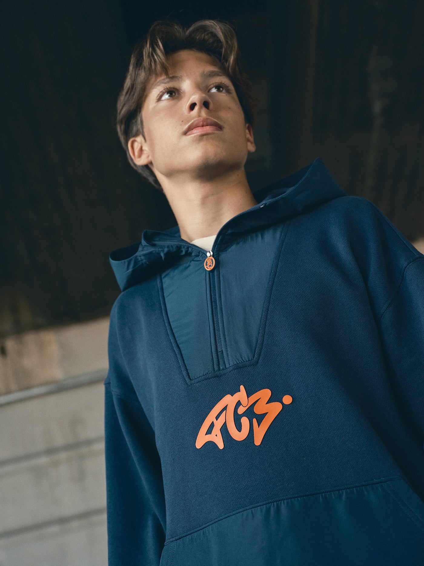 navy blue FC Barcelona hoodie featuring a front zipper and an orange graffiti-style 'FCB' logo printed on the chest