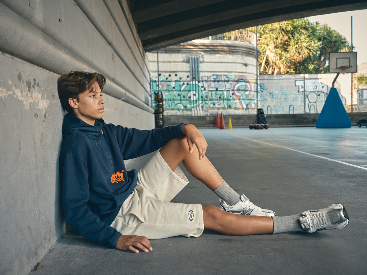 navy blue FC Barcelona hoodie featuring a front zipper and an orange graffiti-style 'FCB' logo printed on the chest