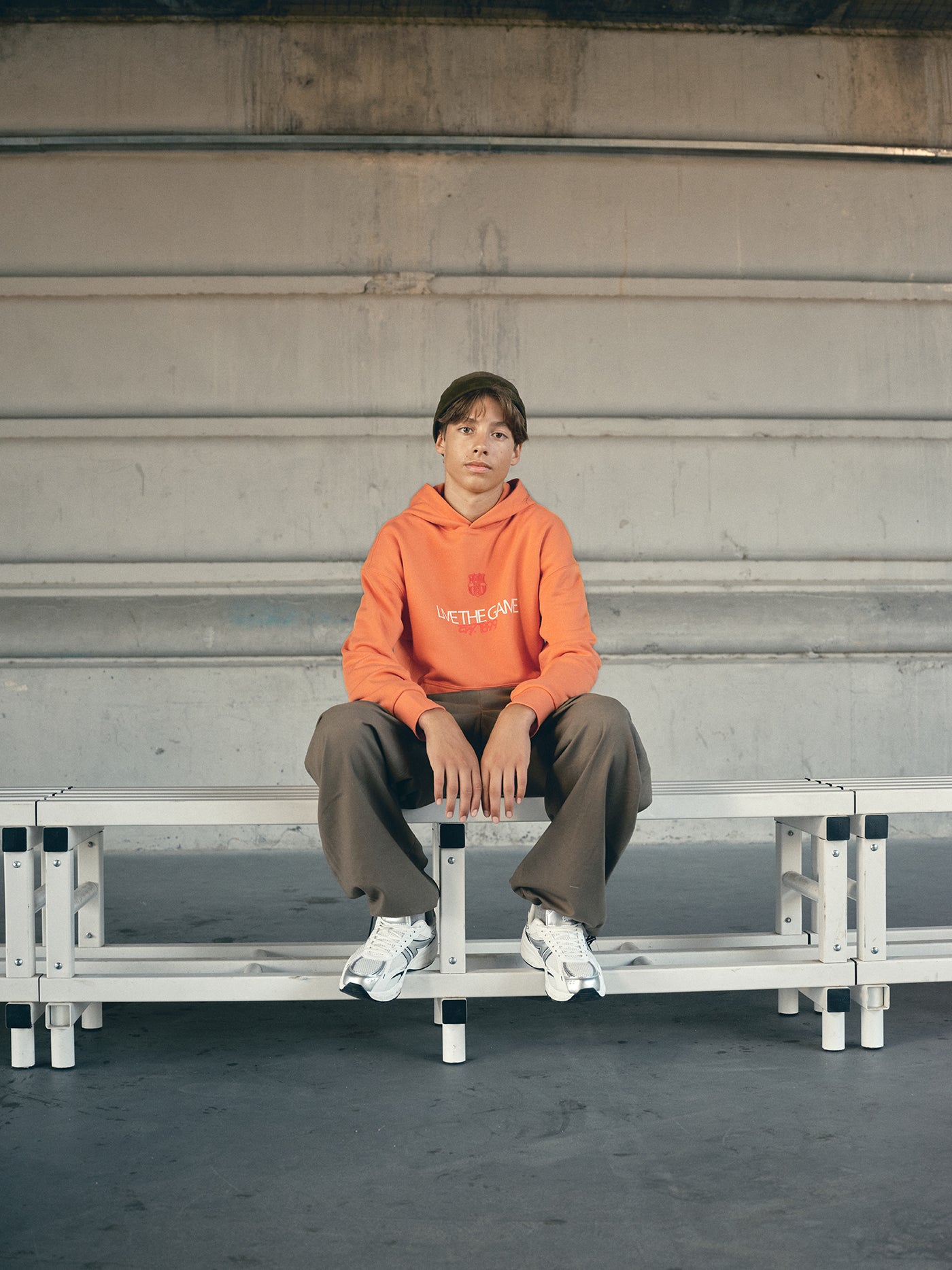 Orange FC Barcelona hoodie featuring the club crest and the slogan 'Live the Game EST. 1899' printed on the front.