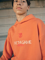 Orange FC Barcelona hoodie featuring the club crest and the slogan 'Live the Game EST. 1899' printed on the front.