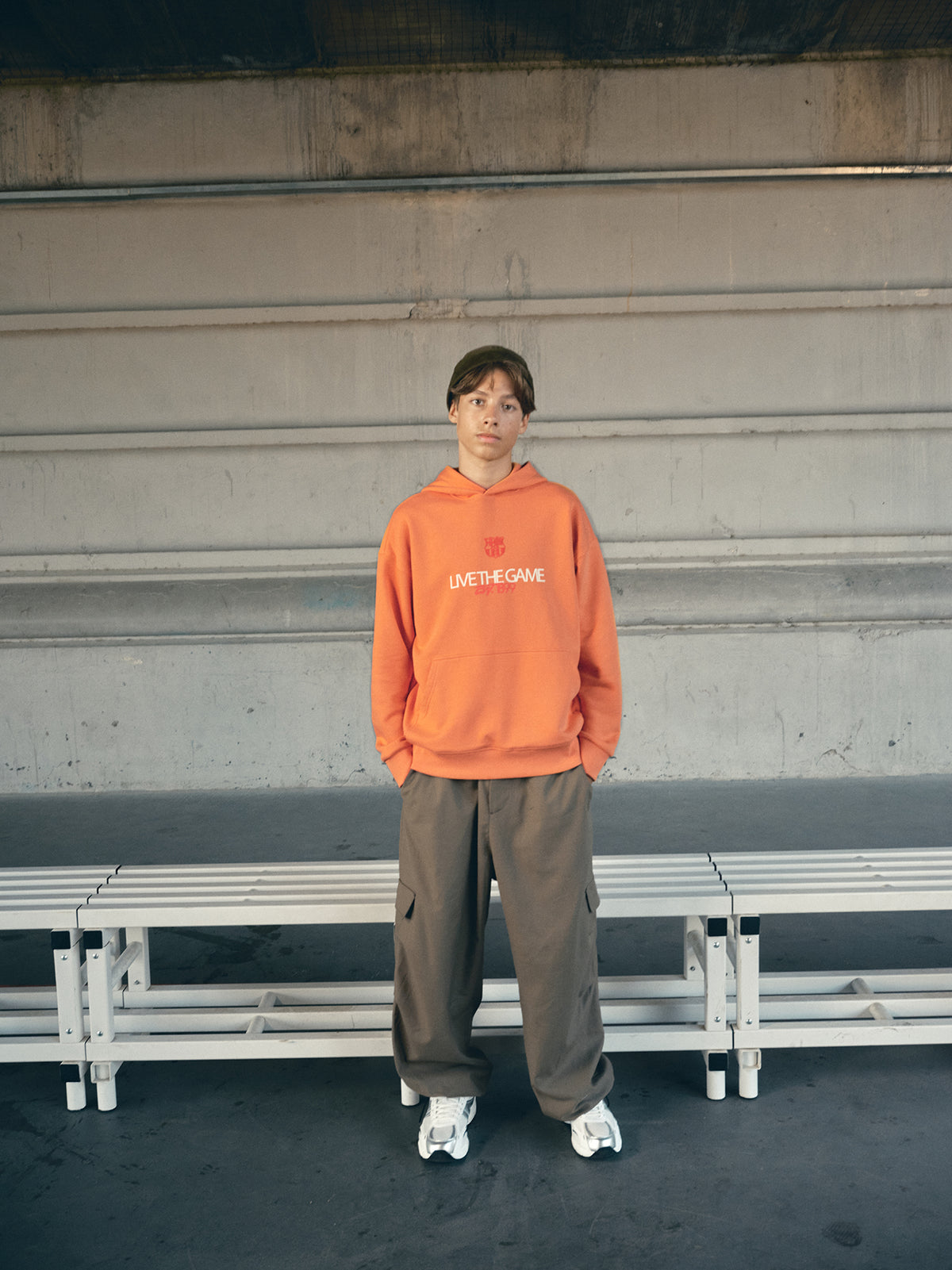 Orange FC Barcelona hoodie featuring the club crest and the slogan 'Live the Game EST. 1899' printed on the front.