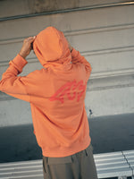 Orange FC Barcelona hoodie featuring the club crest and the slogan 'Live the Game EST. 1899' printed on the front.