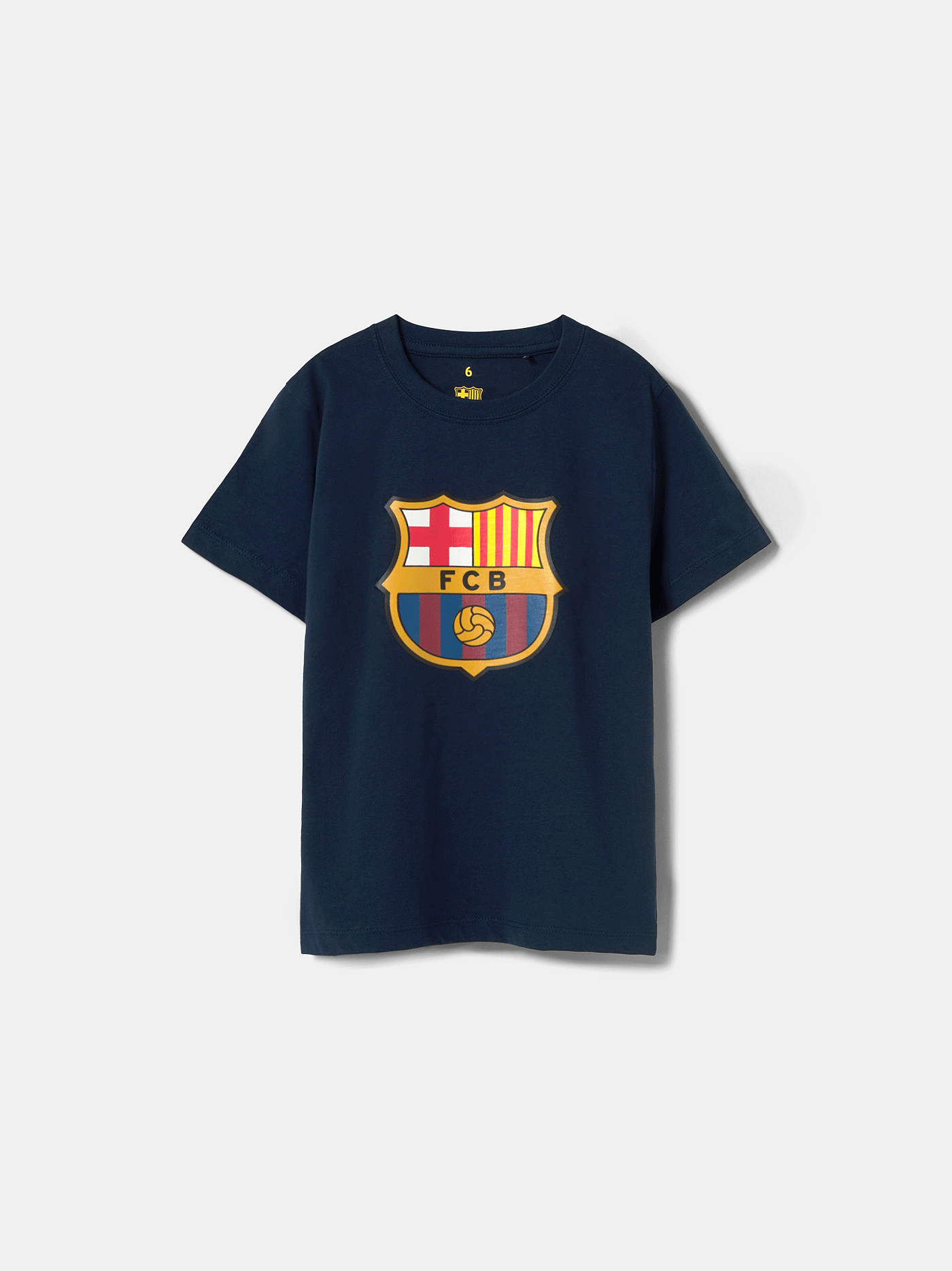 Back view of a navy blue FC Barcelona t-shirt featuring the phrase "MÉS QUE UN CLUB" in large, dark typography. Surrounding the text are red player autographs and jersey numbers, along with four yellow and red vertical bars representing the Catalan flag (senyera) near the neck.
