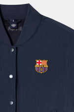Navy blue FC Barcelona bomber jacket with red bands on the sleeves. The jacket features the club crest on the left chest and the year "1899" on the right chest, with a front snap button closure and ribbed cuffs and hem.