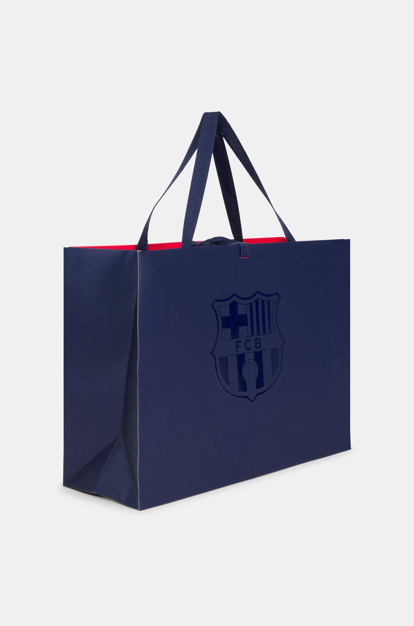 Dark blue FC Barcelona gift bag with glossy club crest on the front and dark blue handles, featuring a red interior.