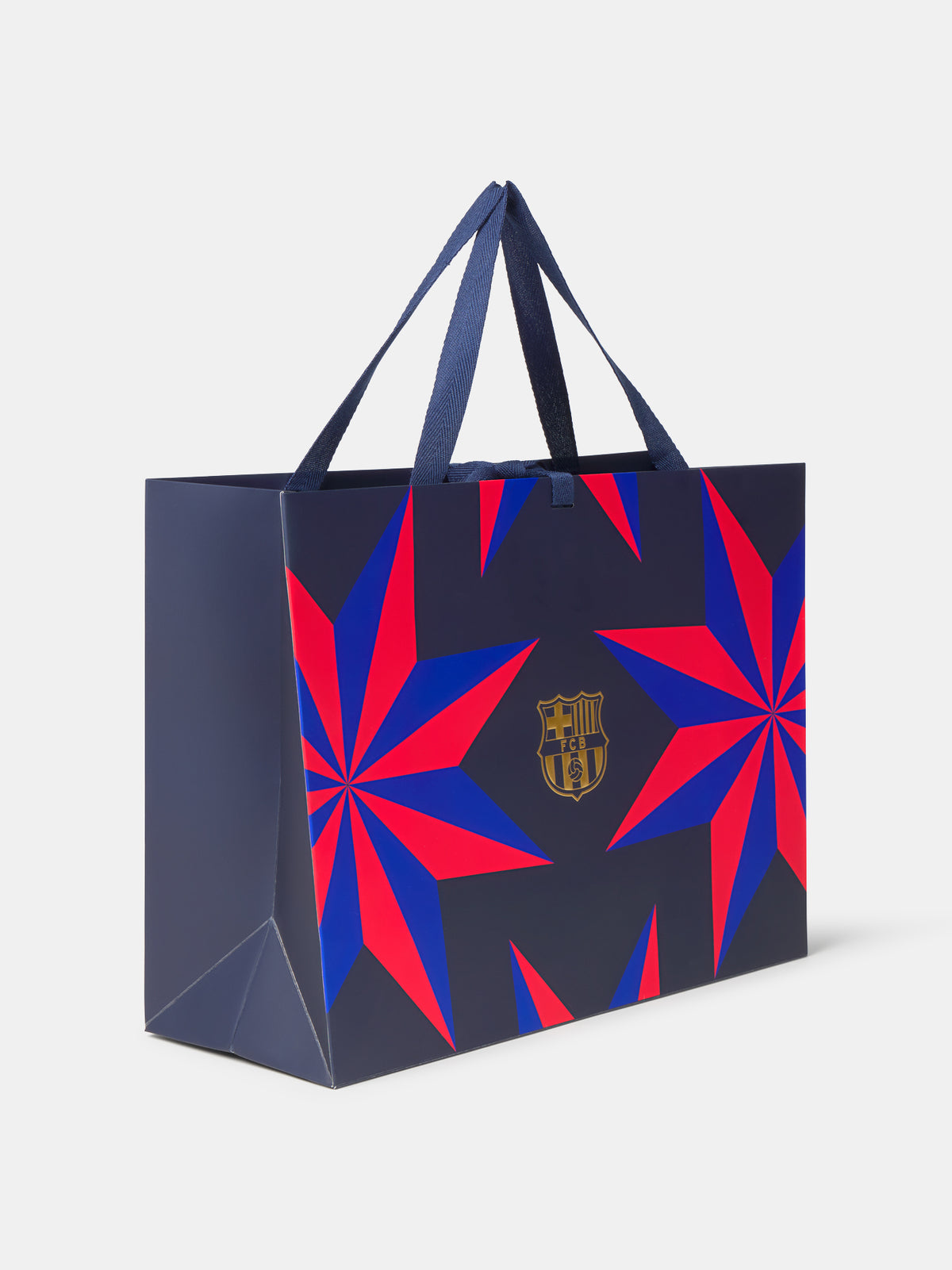 Bolsa de compra azul marino del FC Barcelona con gráficos de estallido en rojo y azul, escudo dorado y asas de tela.