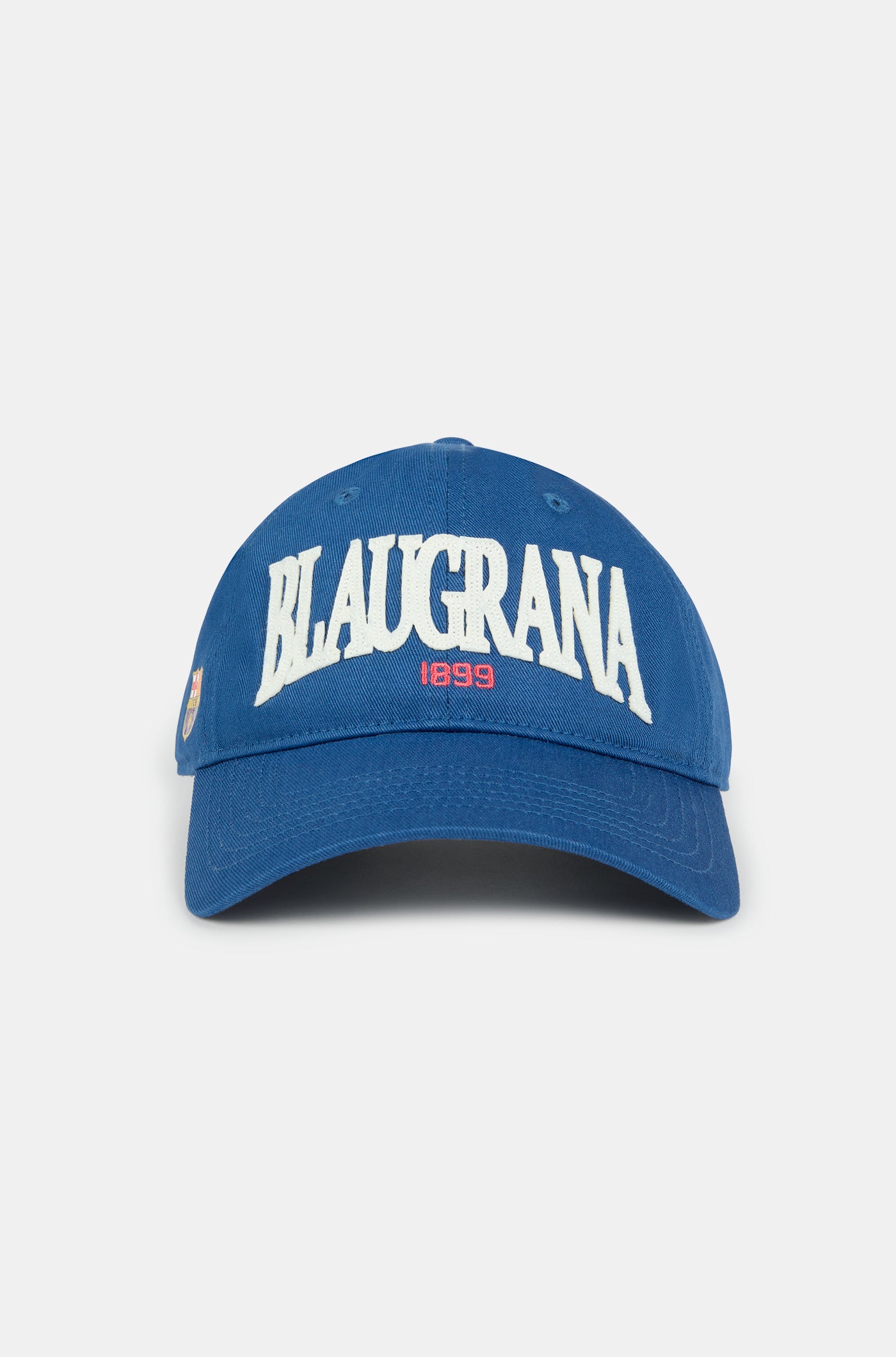 Blue FC Barcelona cap with "BLAUGRANA 1899" embroidered in white and red on the front, featuring a curved brim and a small Barça crest on the side.



