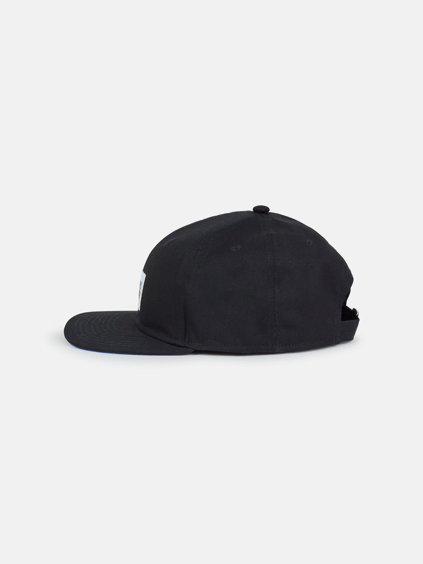 Black flat-brim cap featuring a rectangular white patch on the front with the FC Barcelona crest and the slogan "Més que un club" printed in black.