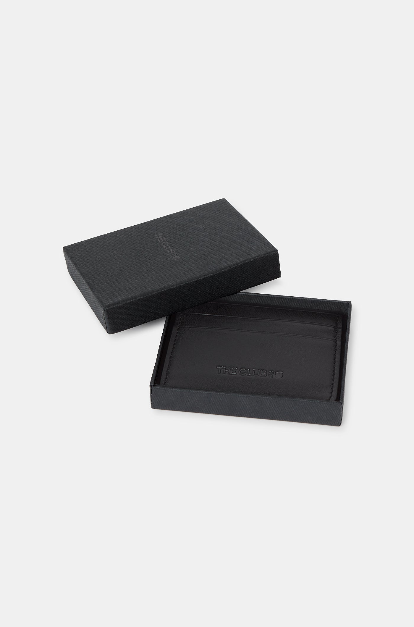 Black leather cardholder with embossed “THE CLUB” text on the front, featuring two horizontal card slots.