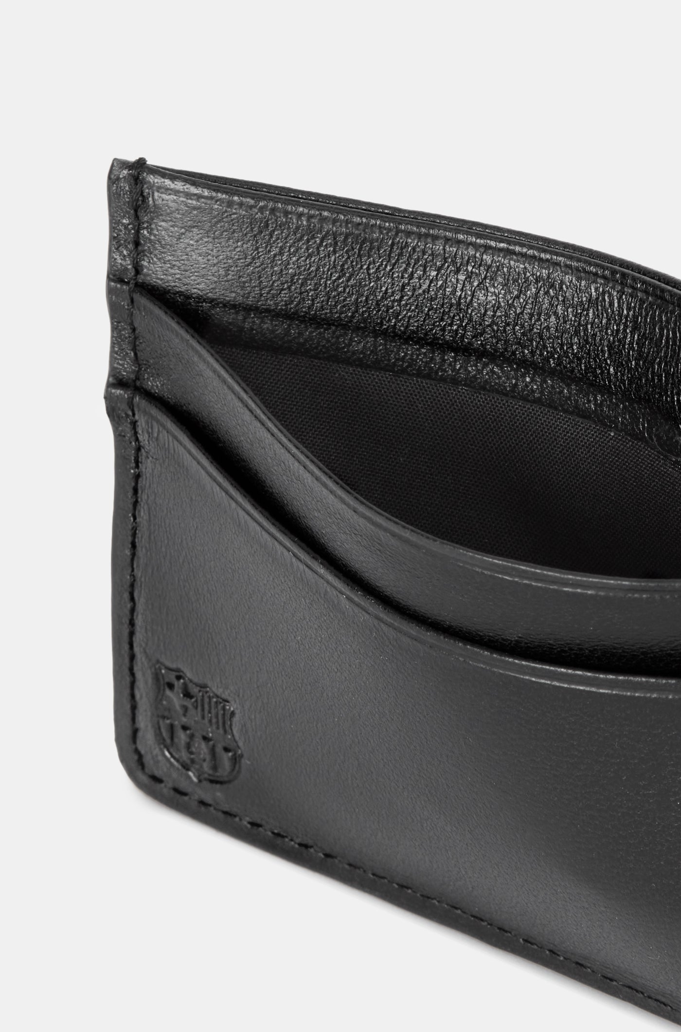 Black leather cardholder with embossed “THE CLUB” text on the front, featuring two horizontal card slots.