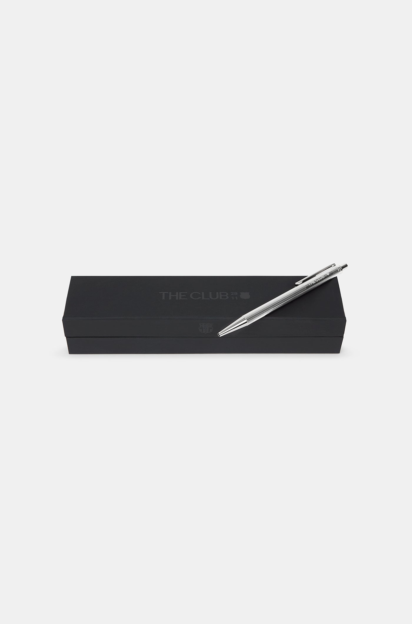 Close-up of a silver metallic pen engraved with "THE CLUB" and a small FC Barcelona logo.