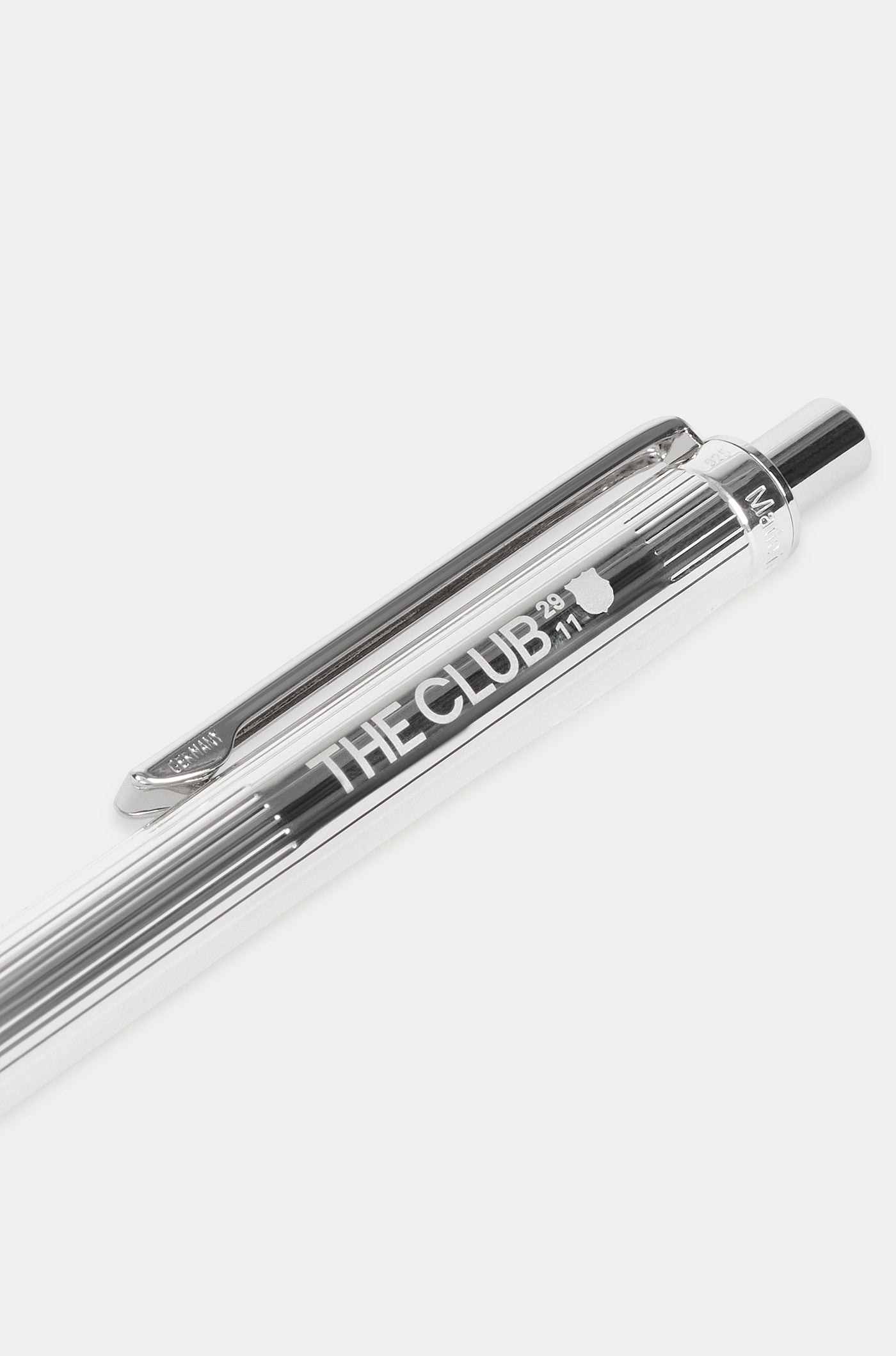 Close-up of a silver metallic pen engraved with "THE CLUB" and a small FC Barcelona logo.
