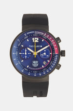 Black wristwatch with FC Barcelona crest, presented in a black box. The watch face is predominantly blue with red and blue details on the dial, white markings, and a yellow second hand.