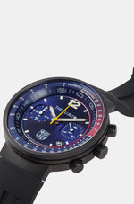 Black wristwatch with FC Barcelona crest, presented in a black box. The watch face is predominantly blue with red and blue details on the dial, white markings, and a yellow second hand.