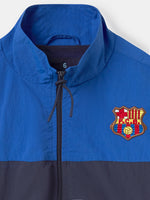 Color-block windbreaker jacket in blue, red, and navy with FC Barcelona crest on the chest