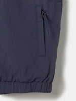 Color-block windbreaker jacket in blue, red, and navy with FC Barcelona crest on the chest