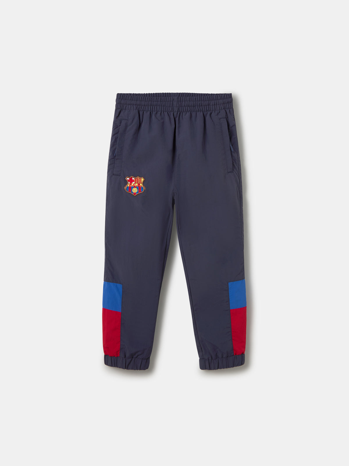 Navy jogger pants with FC Barcelona crest on the upper leg and red and blue color blocks on the knees.