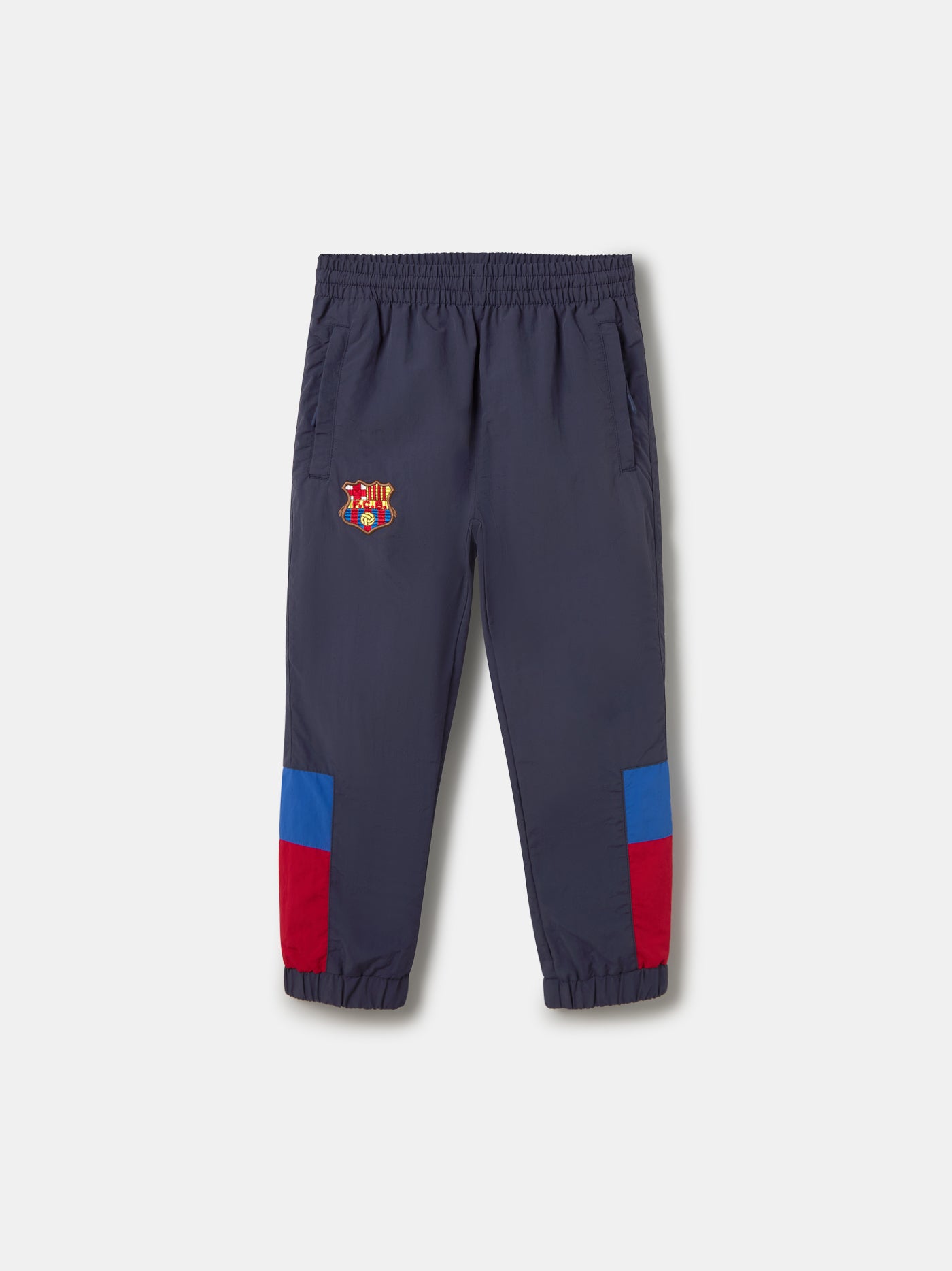 Navy jogger pants with FC Barcelona crest on the upper leg and red and blue color blocks on the knees.