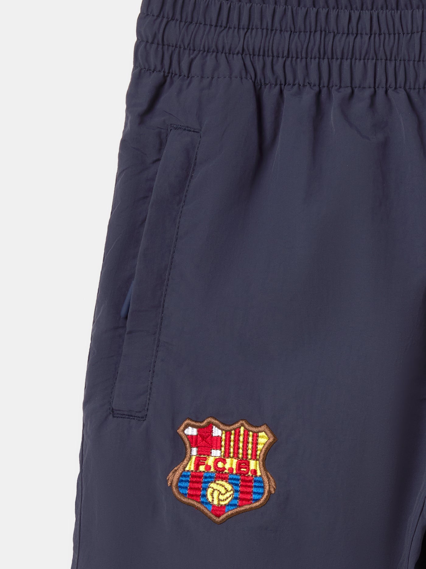 Navy jogger pants with FC Barcelona crest on the upper leg and red and blue color blocks on the knees.