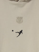 White FC Barcelona hoodie featuring the club's crest and a silhouette of Johan Cruyff performing a volley printed on the chest.