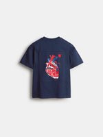 Back view of a navy FC Barcelona T-shirt with a large rectangular graphic print on the back featuring a stylized red and blue heart.