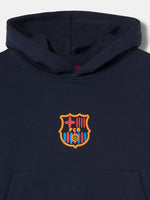 navy blue FC Barcelona hoodie featuring the club crest on the chest and "Barça" embroidered on the sleeve.
