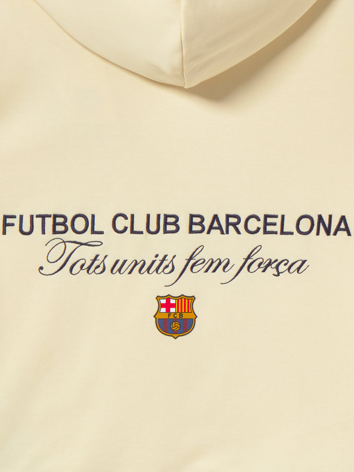 Beige FC Barcelona hoodie for kids, featuring a colorful 'Barça' text on the front and 'Futbol Club Barcelona - Tots units fem força' with the club crest on the back