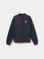 Navy blue FC Barcelona varsity jacket with embroidered 1899 detail, club crest on the chest, and red striped collar, cuffs, and hem.