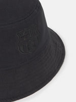 Black bucket hat with dotted pattern and 'Barça' text in blue.