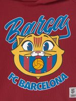  red FC Barcelona hoodie with the text 'Barça' and a cartoon illustration of Cat Culer, the club's mascot, on the front.