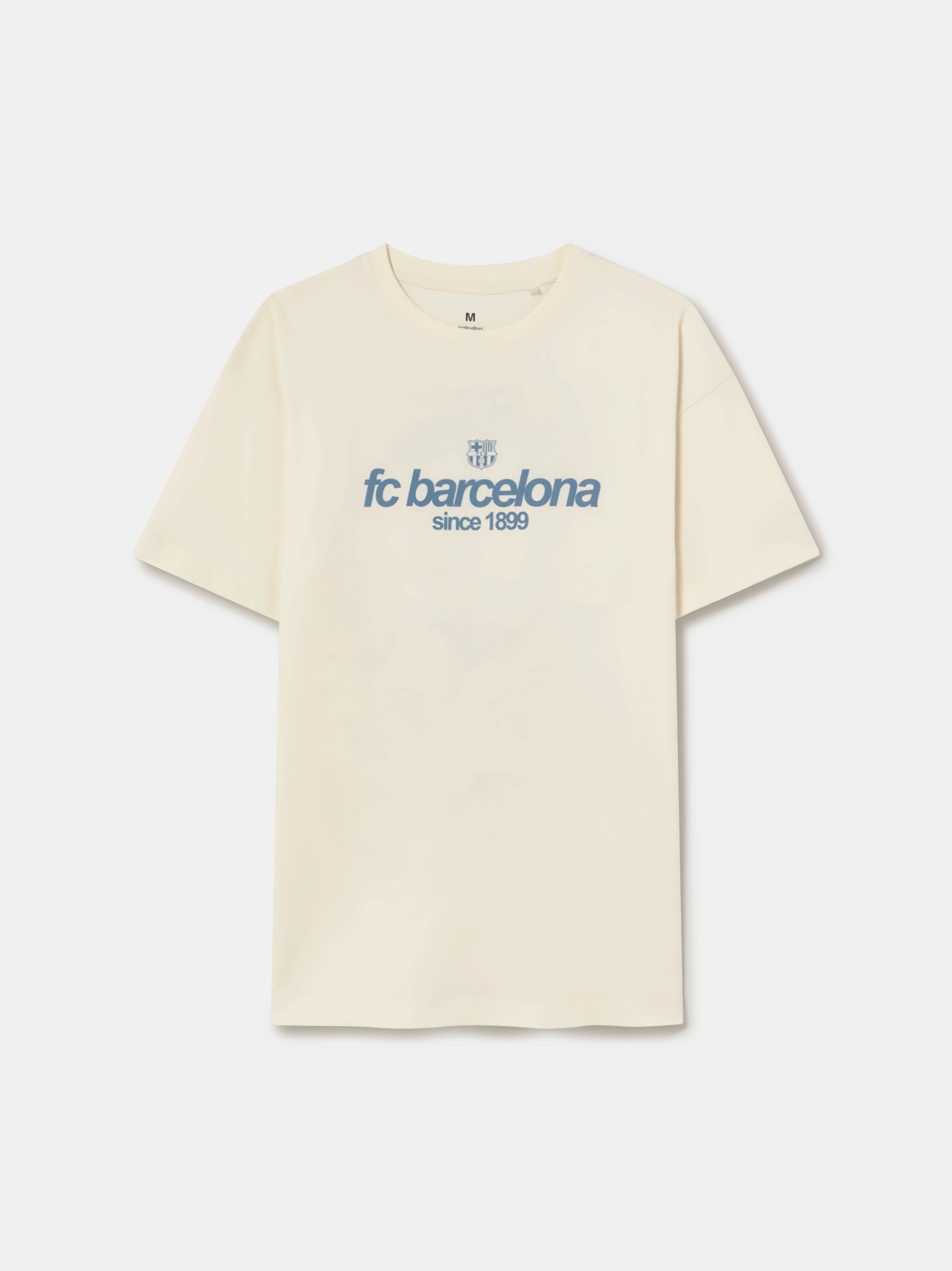 Off-white T-shirt featuring an illustrated graphic of Lamine Yamal with FC Barcelona elements and 'fc barcelona' text on the back.