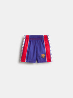 Vue de face du short FC Barcelona bleu avec empiècements latéraux rouges, bandes latérales blanches et écusson du club sur la jambe.