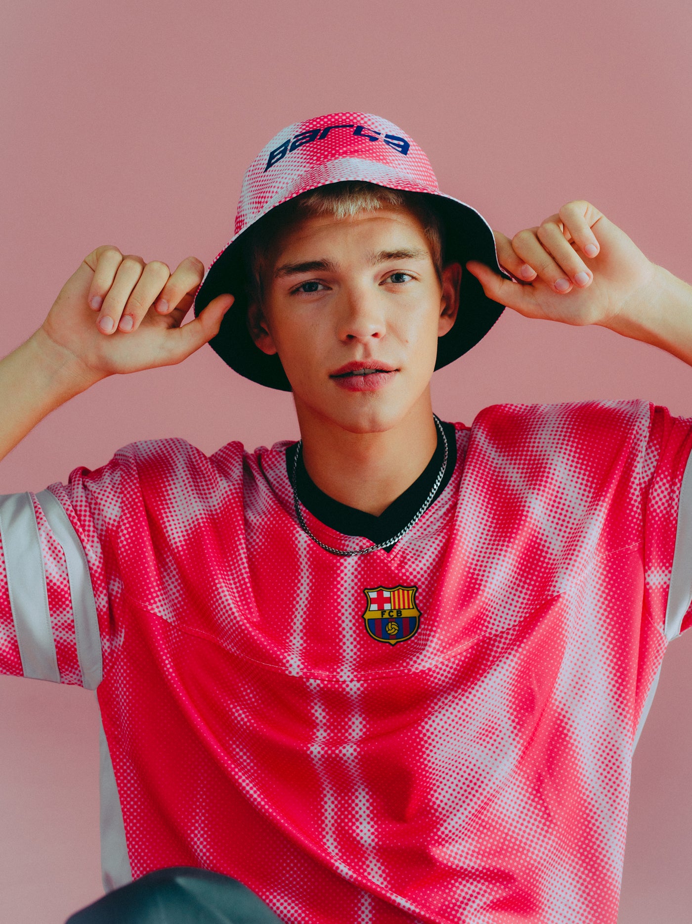 Pink and white bucket hat with dotted pattern and 'Barça' text in blue.