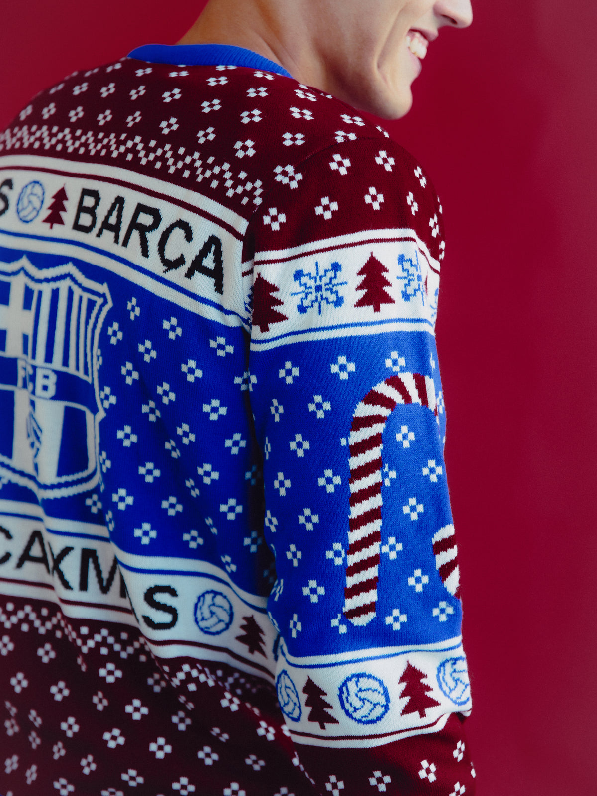 Vista trasera de un jersey de punto de FC Barcelona con estampados navideños azul y grana y el escudo del Barça en la manga.