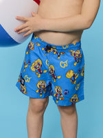 Person wearing blue swim shorts with cartoon characters against a blue background