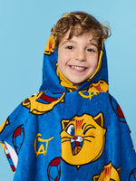 Child wearing a blue cartoon-themed poncho against a blue background