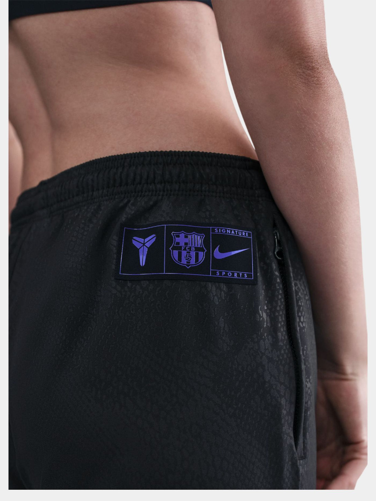 Black FC Barcelona training pants featuring the Kobe Bryant logo and 'FC Barcelona' text in purple on the right thigh.