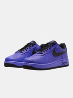 Purple sneakers with black accents on a light gray background