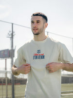 Man wearing a white t-shirt with text and logo outdoors
